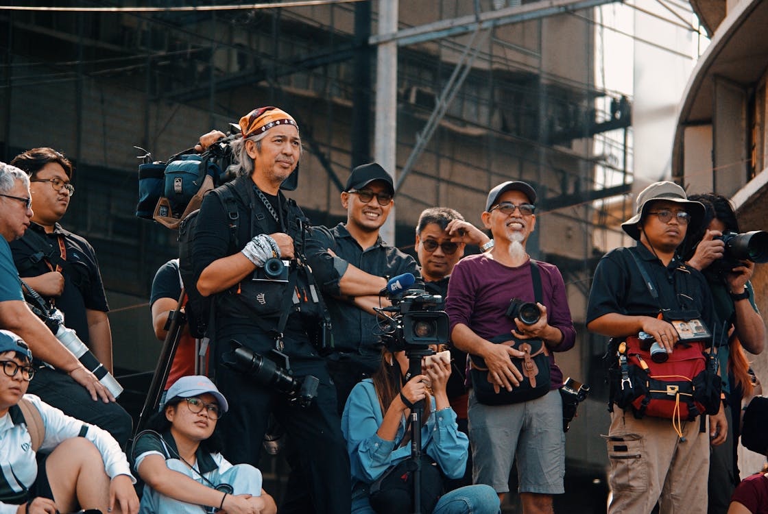 A crowd of photographers and filmmakers smiling together